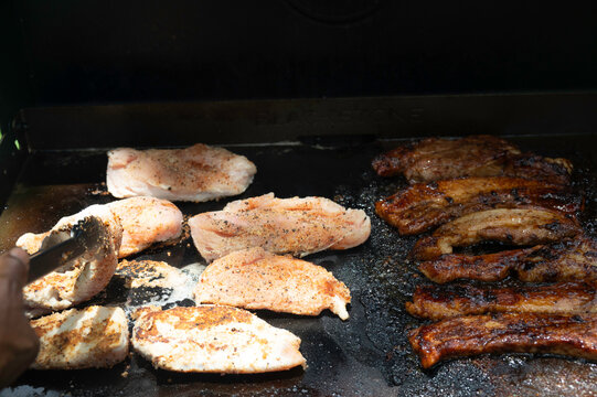 Grilling Marinated Chicken and Pork Ribs in Outdoor Kitchen