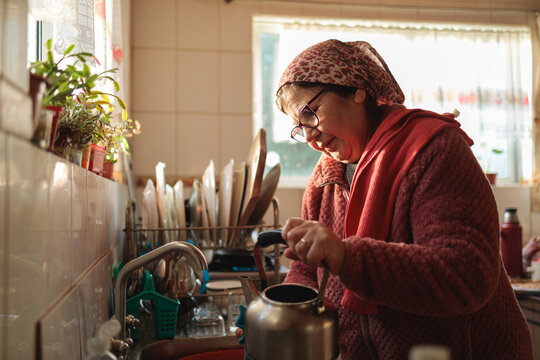 Elder Woman Washing a Kettle in Morning Sunlight
