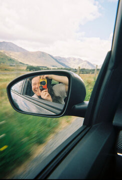 Disposable Camera Reflected in Car Side Mirror