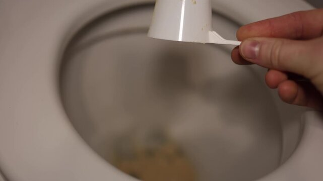 Protein powder dumped into toilet bowl expressing frustration with ineffective supplement symbolic scene of wasted nutrition and disappointment in fitness resultsм