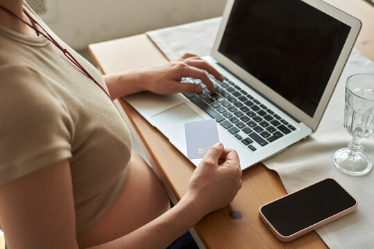 Pregnant woman making online payment  at home