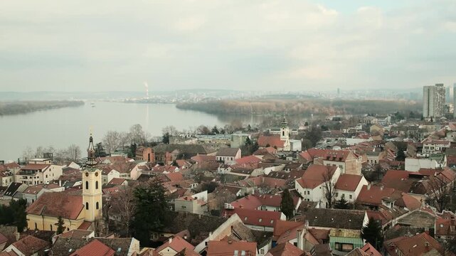 Panoramic view of Zemun with red rooftops and church towers along the Danube River in Belgrade. Historic waterfront district and urban skyline highlighting European architecture and city landscape