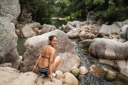 Woman standing on rock before bathing in natural pool