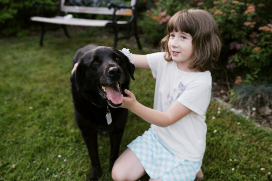 happy dog with little girl in garden at home