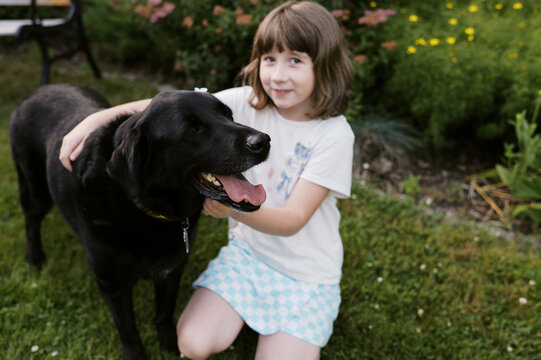 happy dog with little girl in garden at home