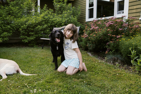 happy dog with little girl in garden at home