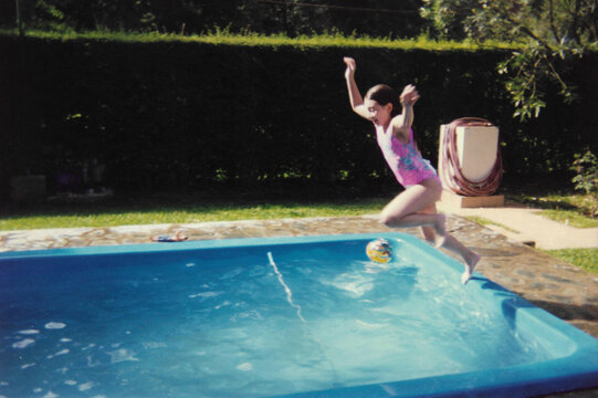Excited child about to leap into backyard pool &ndash; 35mm film, 1990s