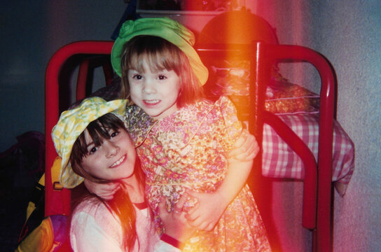 1990s analog photo of two happy sisters hugging