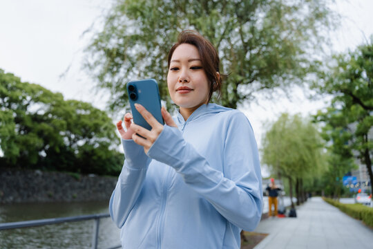 A woman uses a mobile phone while exercising