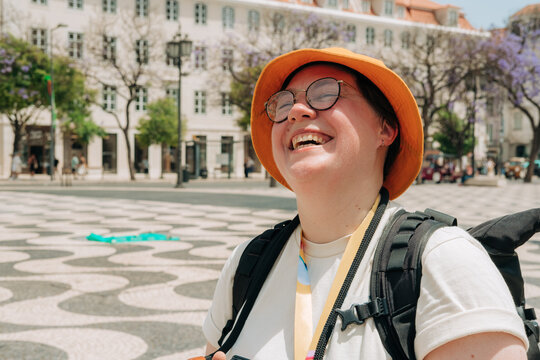 Smiling person with orange hat enjoying sunny city square