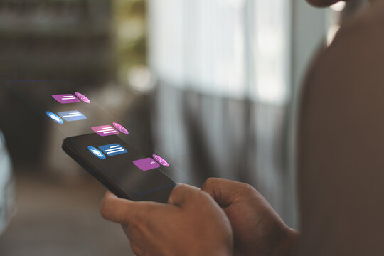 Person using smartphone with AI chatbot interface and digital messaging icons, mobile customer support automation, online communication technology and smart virtual assistant concept.