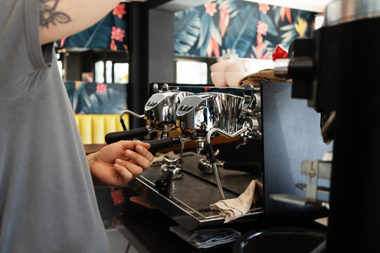 Barista operating espresso machine in busy caf&eacute;