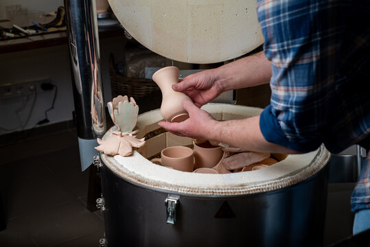 Potter takes the finished clay pots out of the kiln