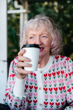 Elderly Woman Drinking a takeaway coffee in Outdoor Setting