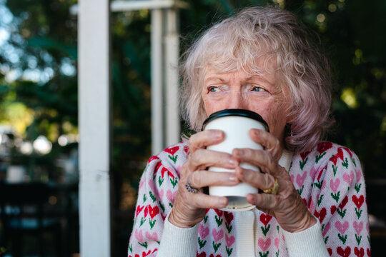 Elderly Woman Drinking a takeaway coffee in Outdoor Setting