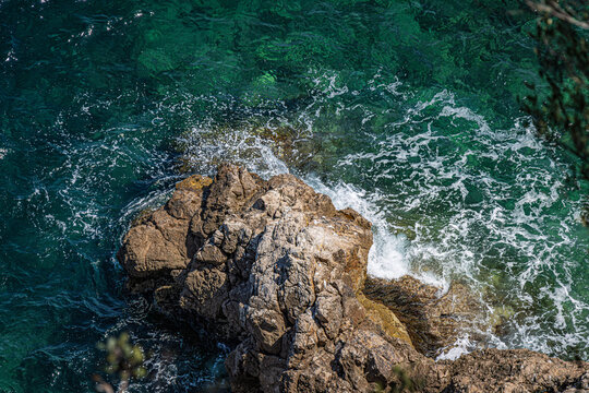 Felsenk&uuml;ste mit Meeresbrandung (Drohnenperspektive)

Luftaufnahme einer felsigen K&uuml;ste mit kristallklarem t&uuml;rkisfarbenem Meerwasser und sch&auml;umender Brandung. Mediterrane K&uuml;stenlandschaft mit nat&uuml;rlich