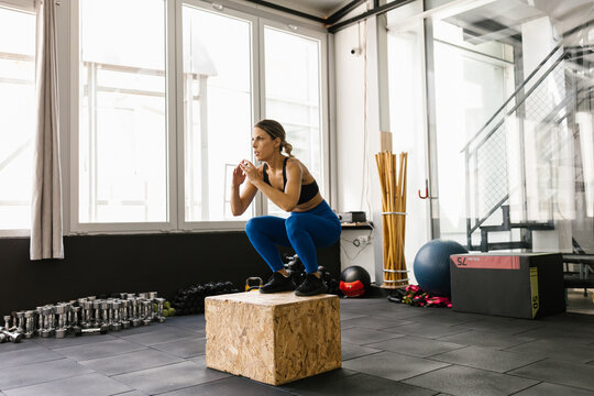 Woman Performs Box Jump Exercise in Modern Gym Studio
