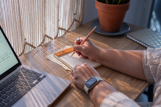 Woman writing ideas into notepad
