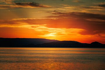 Obraz premium Abendstimmung am Bodensee mit Blick auf das Wasser und untergehender Sonne am Horizont