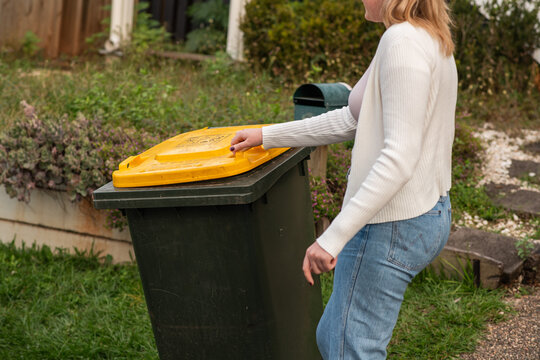 woman bringing in the wheelie bin
