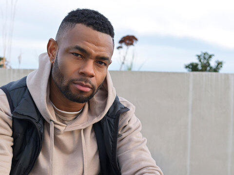 Man Sitting on a Bench in Casual Attire at Outdoor Location