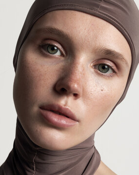  A close-up portrait of a girl with striking green eyes and freckles.