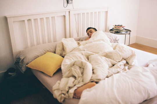 Teen in Bed by Soft Blankets