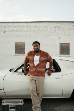 Stylish Man Standing In Front of Vintage Car Outside