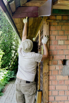 A man repairs a roof on a sunny day