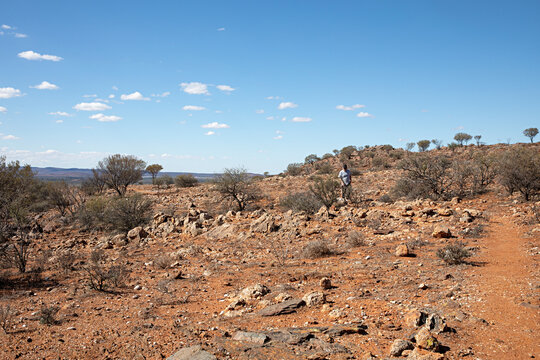 Blue sky and red earth of the Australian outback with man hiking