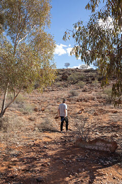 Man's hiking in outback Australia looking at the path. Travel concept.