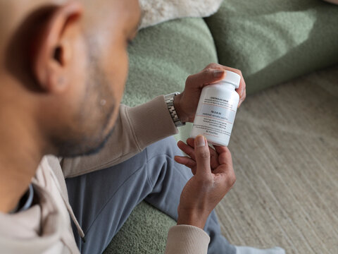 Man Examines Container of Prescription Cannabis Gummies