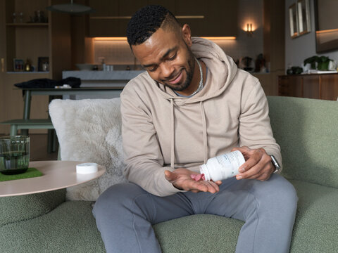 Man taking his prescription cannabis gummy at home