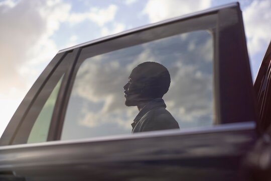 Reflection of a contemplative man seen through a car window