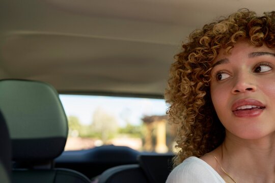 Woman Smiles While Enjoying a Ride in a Car on a Sunny Day