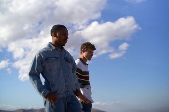 Two young men enjoying a stroll outdoors with blue sky