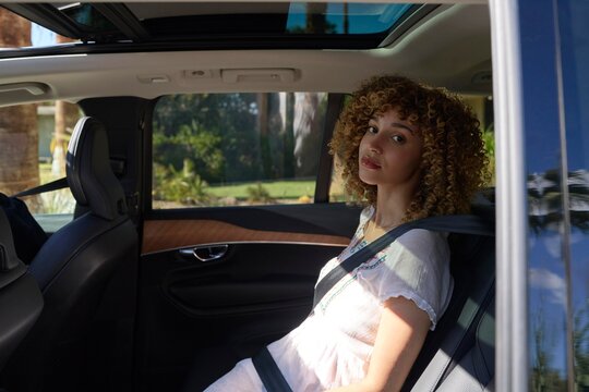 Young woman enjoying ride in back seat of a car