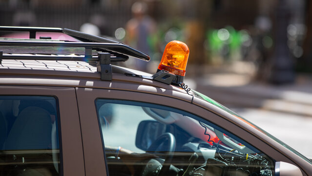 Gros plan sur un gyrophare orange sur une voiture.