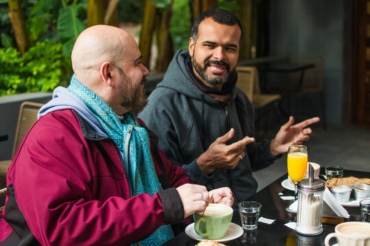 Gay couple lifestyle: talking at the cafe