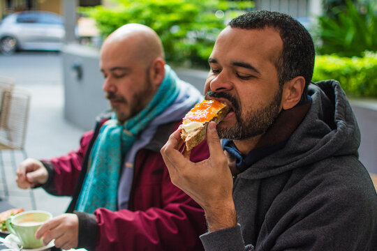 Gay couple having breakfast outdoors