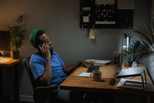 A man is talking on a mobile phone in the office