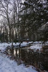 Pałac dworski w mieście Iłowa w zimowy dzień. Część japońska parku z elementami architektury parkowej w postaci lampionów, kładek, schodów, altanek, stawu parkowego i strumyka. © boguslavus