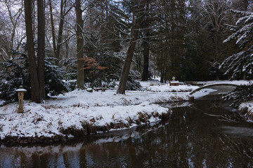 Pałac dworski w mieście Iłowa w zimowy dzień. Część japońska parku z elementami architektury parkowej w postaci lampionów, kładek, schodów, altanek, stawu parkowego i strumyka. © boguslavus