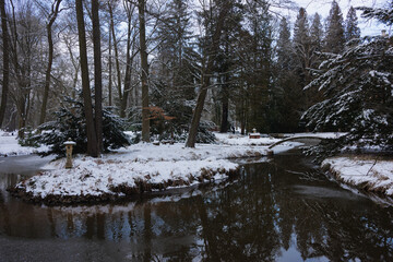 Pałac dworski w mieście Iłowa w zimowy dzień. Część japońska parku z elementami architektury parkowej w postaci lampionów, kładek, schodów, altanek, stawu parkowego i strumyka. © boguslavus