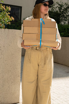 Delivery person carrying multiple packages in urban setting