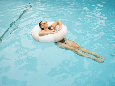 Woman Relaxing in Pool on a Sunny Day With a Float Ring