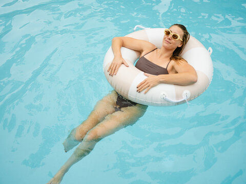 Woman Relaxing in Pool With Float on a Sunny Day