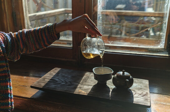 a woman's hand pouring tea