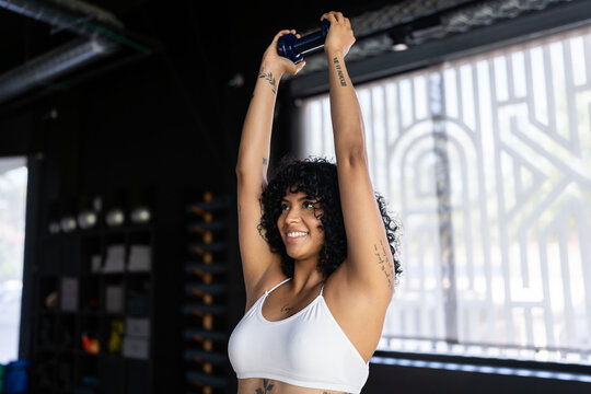 Young woman lifting weights during fitness training in the gym
