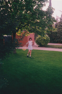 Girl Playing Tennis in Backyard